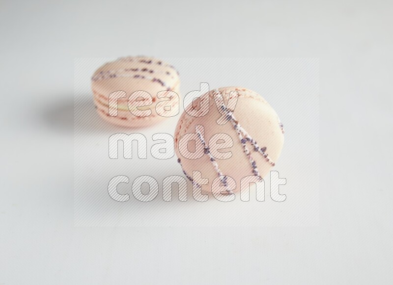 45º Shot of two pink orange blossom macarons on white background