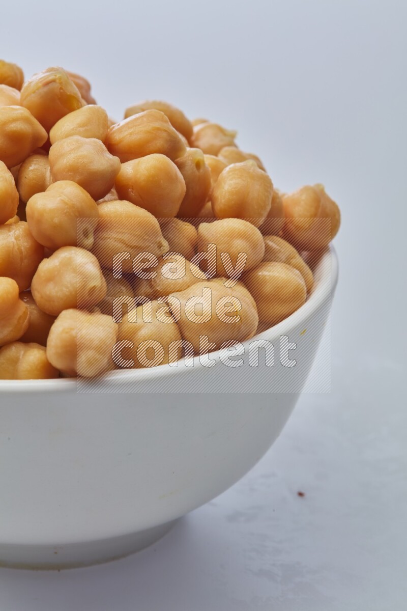 Close up shot of boiled chickpeas in a container on white background