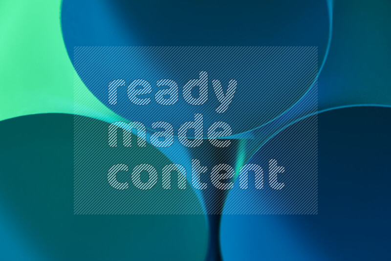 الصورة تعرض فن ورقي تجريدي بأشكال دائرية بدرجات متنوعة من اللون الأخضر والأزرق