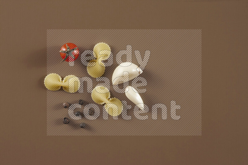 Raw pasta with different ingredients such as cherry tomatoes, garlic, onions, red chilis, black pepper, white pepper, bay laurel leaves, rosemary and cardamom on beige background