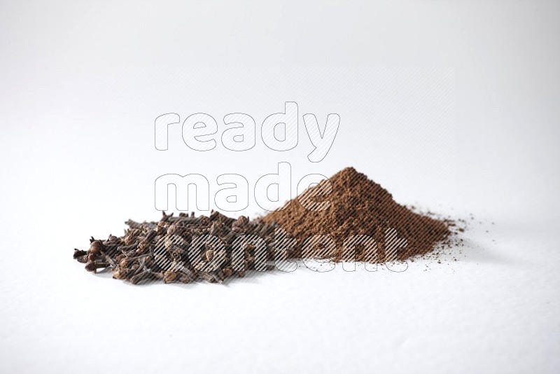 2 piles of cloves grains and cloves powder on a white flooring