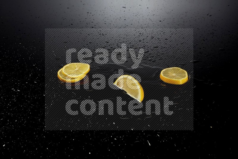 Lemon slices with water drops, and droplets on black background