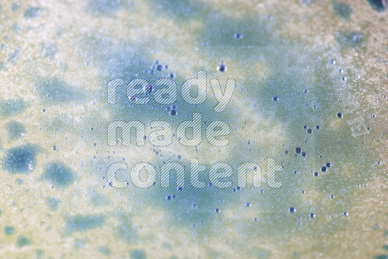 Close-ups of abstract blue watercolor drops on oil Surface on white background