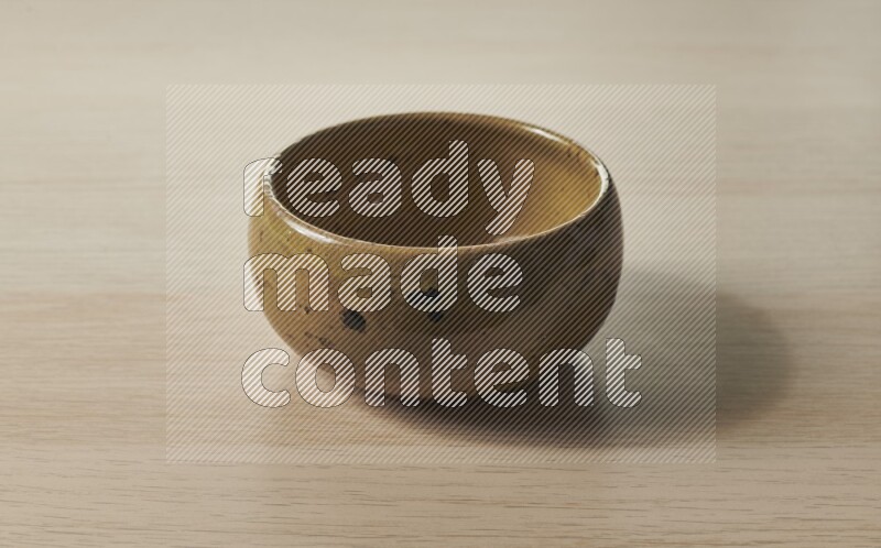 وعاء فخاري متعدد الألوان على خلفية خشبية فاتحة