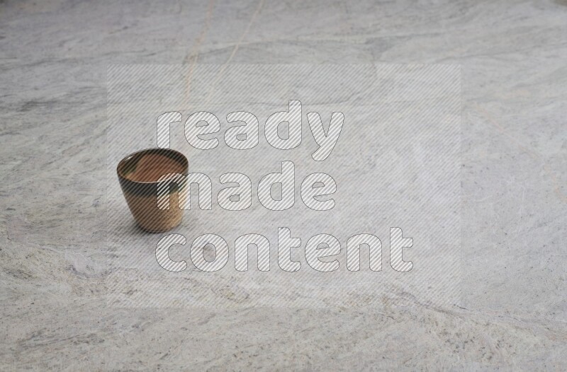 A multicolored pottery Cup on grey marble background