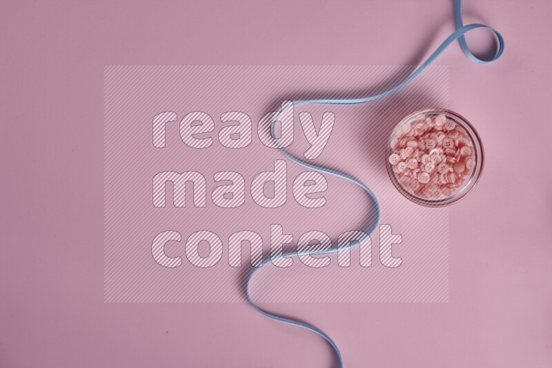 مجموعة من أدوات الخياطة والتفصيل زرقاء اللون على خلفية زهرية