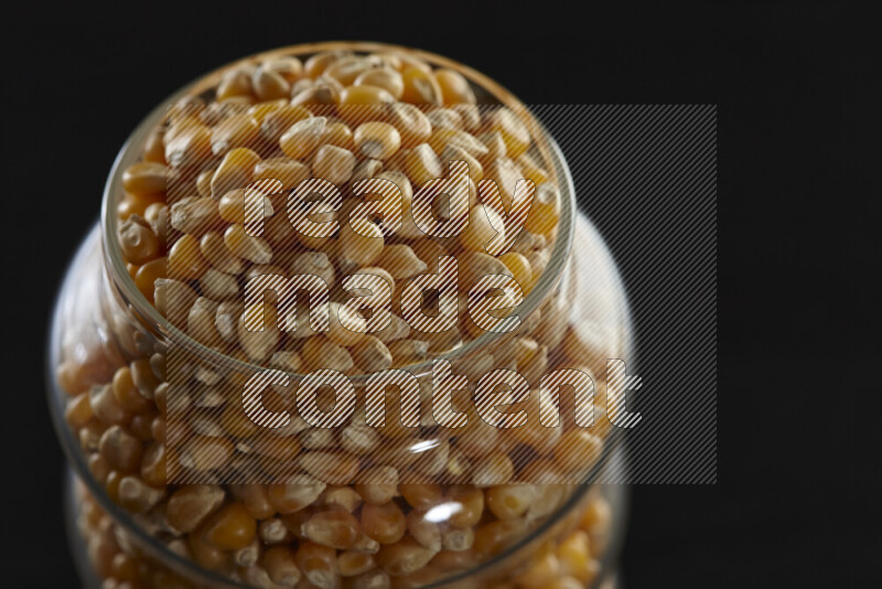 Pop corn in a glass jar on black background