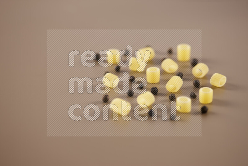 معكرونة مع مكونات متنوعة من الطماطم والثوم والبصل والفلفل الأحمر والفلفل الأسود والفلفل الأبيض وأوراق الغار وإكليل الجبل والهيل على خلفية بيج