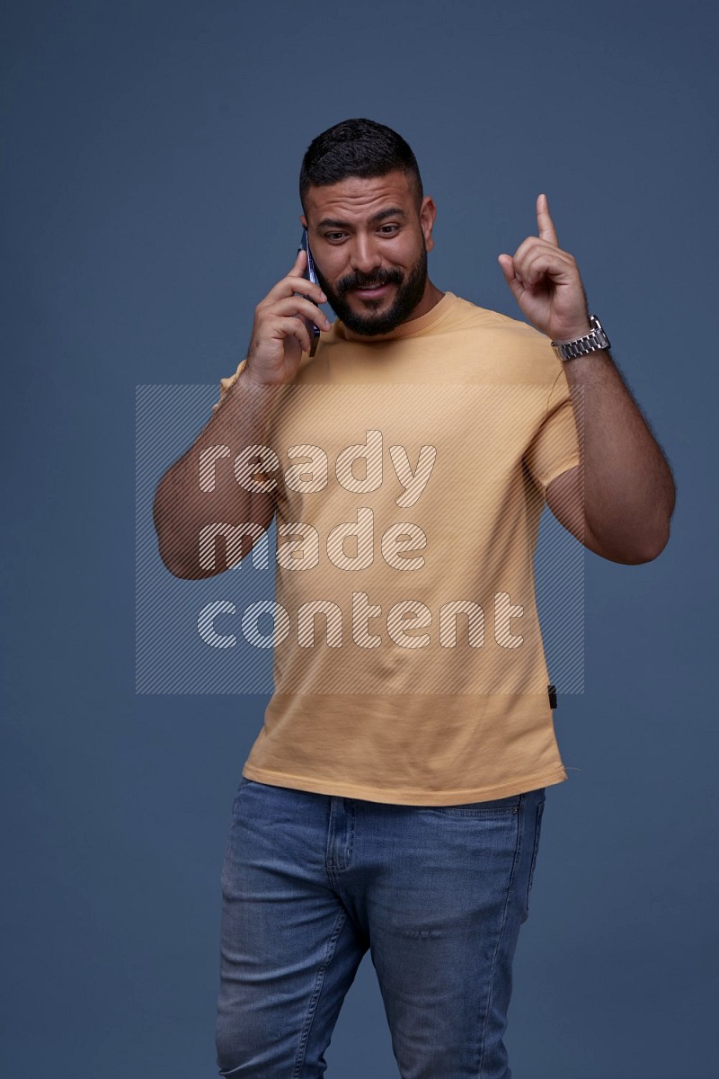 A man Calling on Blue Background wearing Orange T-shirt