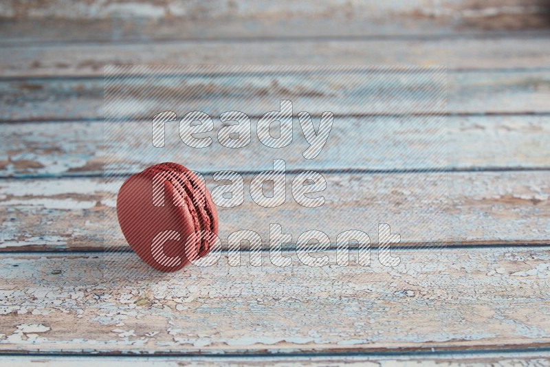 45º Shot of Red Velvet macaron on light blue wooden background