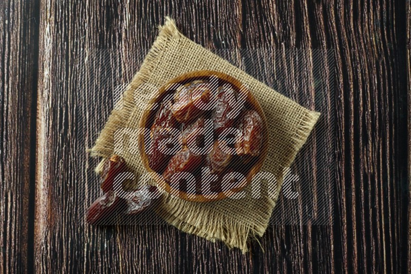 Dates in different bowls (wooden, pottery and glass) on wooden background