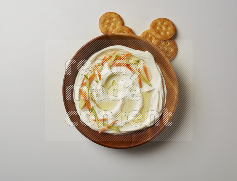 Lebnah garnished with sliced carrots & cucumber in a wooden plate on a white background