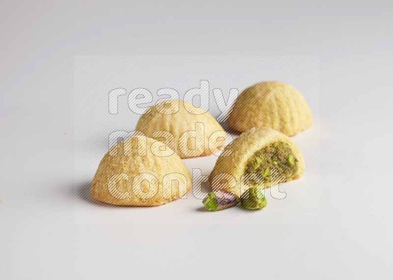 Four Pieces of Maamoul filled with pistachio  paste one of them is cut direct on white background