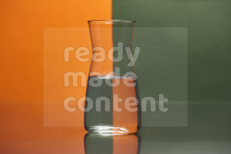 The image features a clear glassware filled with water, set against orange and dark green background