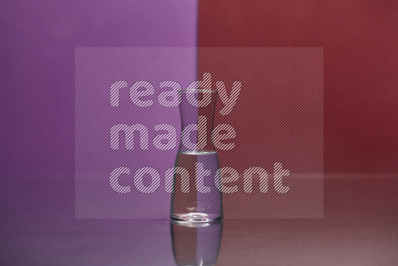 The image features a clear glassware filled with water, set against purple and dark red background