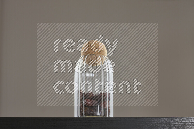 Dates in a glass jar on black background