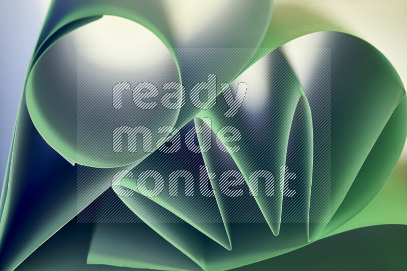 عرض فني لطيات الورق تخلق مزيج من الأشكال الهندسية، مضاءة بإضاءة ناعمة بدرجات اللون الأخضر