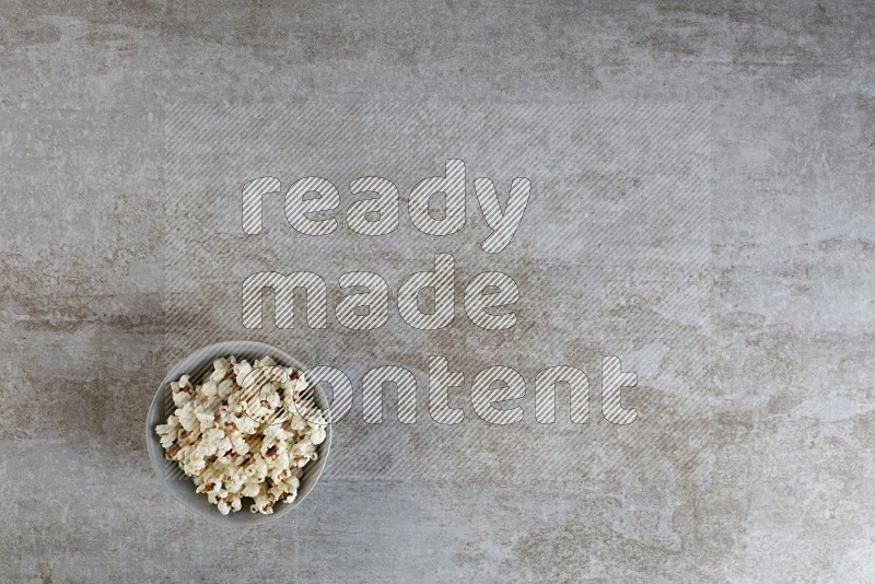 popcorn in gray bowl on a grey textured countertop