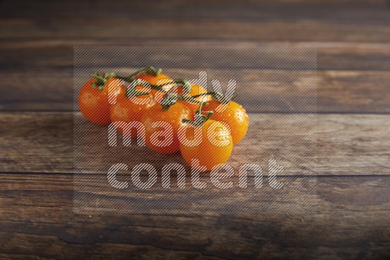 Orange cherry tomato vein on a textured wooden background 45 degree