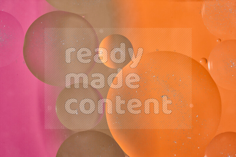 لقطات مقربة لفقاعات من الزيت على سطح الماء باللون البني والبرتقالي والوردي