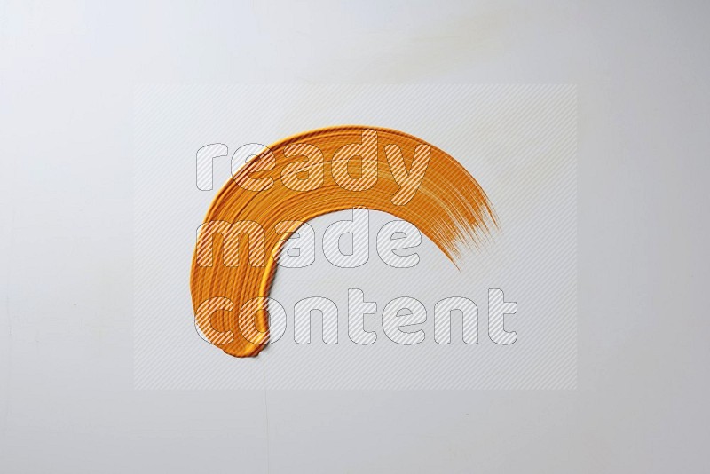 An orange half circular painting brush stroke on white background