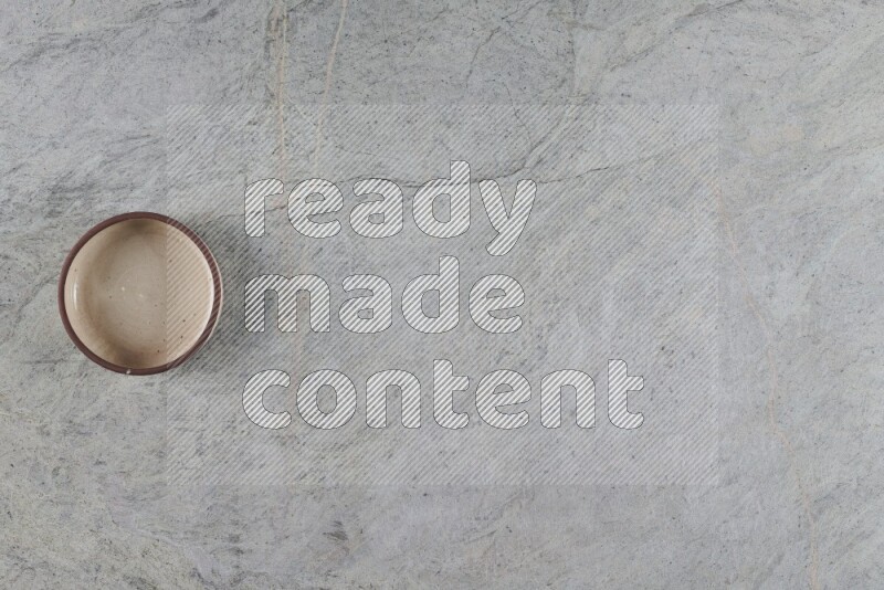 A multicolored pottery oven bowl on grey marble background