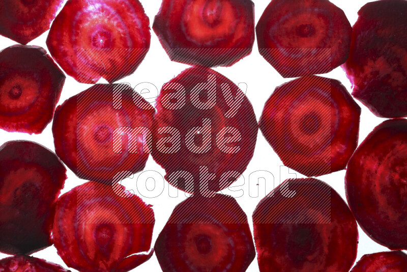 Beet slices on illuminated white background