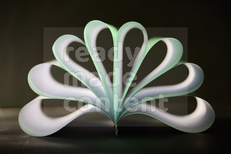 An abstract art piece displaying smooth curves in green and white gradients created by colored light