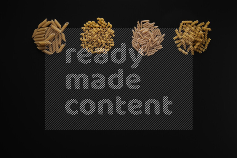 Different pasta types in 4 bunches on black background