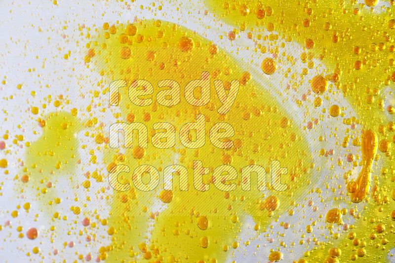 Close-ups of abstract yellow and red watercolor drops on oil Surface on white background