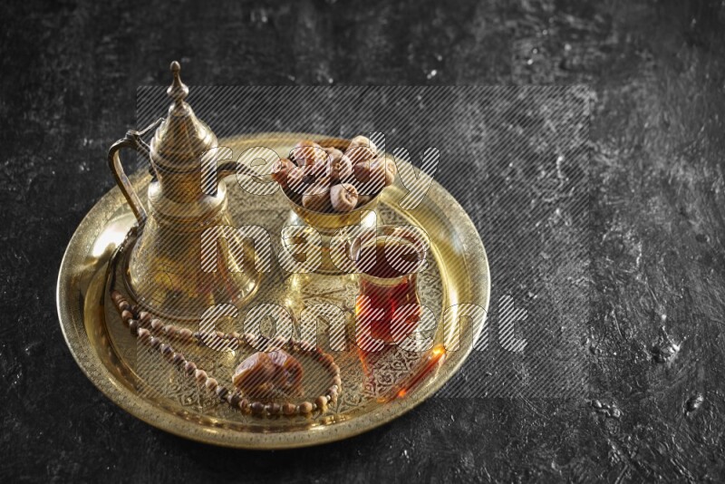 تمر مع مشروب ساخن على صينية معدنية