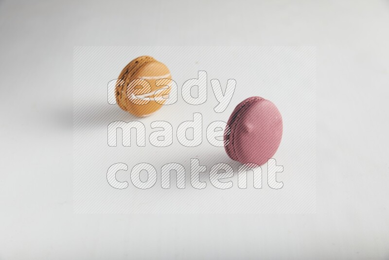 45º Shot of of two assorted Brown Irish Cream, and Red Cherry macarons on white background
