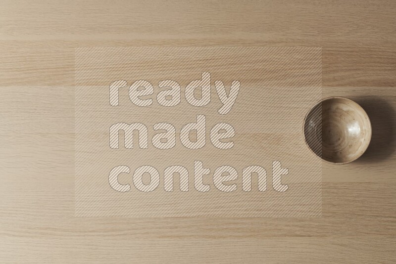 وعاء فخاري بيج على خلفية خشبية فاتحة