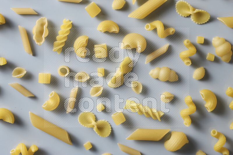 Different pasta types on light blue background