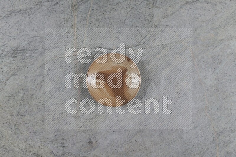 A multicolored pottery plate on grey marble background