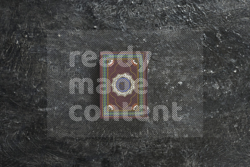 Quran with a prayer beads on textured black background