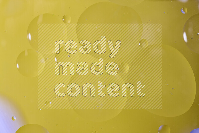 Close-ups of abstract oil bubbles on water surface in shades of yellow