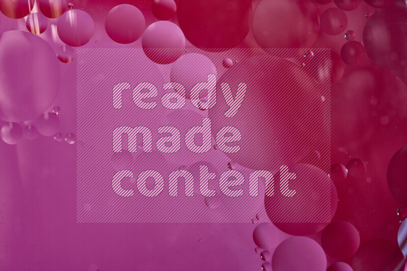 لقطات مقربة لفقاعات من الزيت على سطح الماء باللون الأحمر والوردي