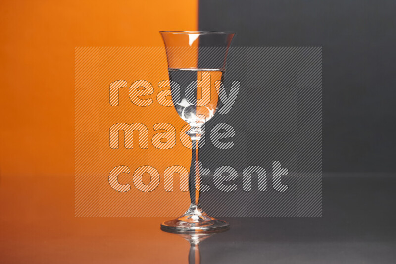 The image features a clear glassware filled with water, set against orange and black background