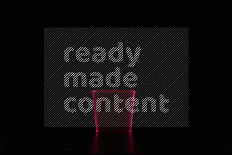 A plant pot with colored rim light against black background