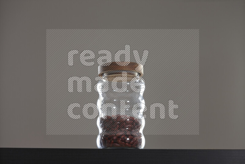 Red kidney beans in a glass jar on black background