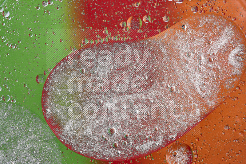 Close-ups of abstract oil bubbles on water surface in shades of orange, green and red