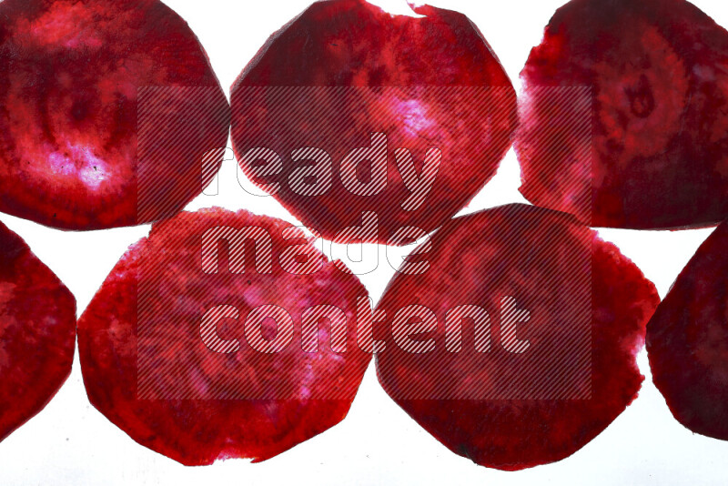 Beet slices on illuminated white background