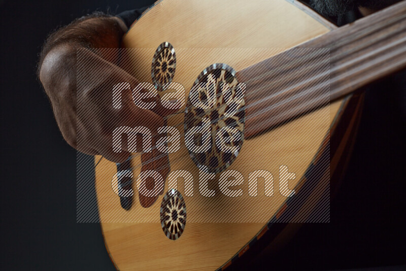 يد رجل تعزف على عود خشبي بني