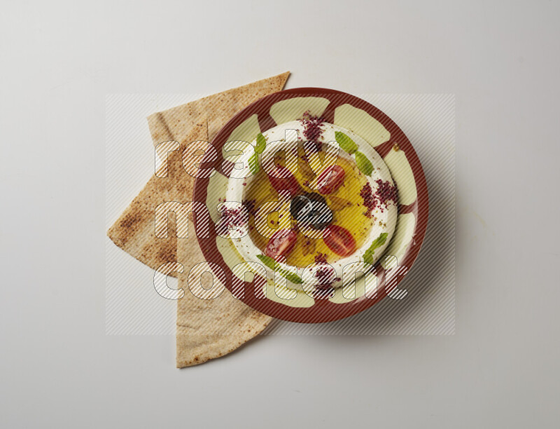 Lebnah garnished with Cherry tomato, mint & sumak  in a traditional plate on a white background