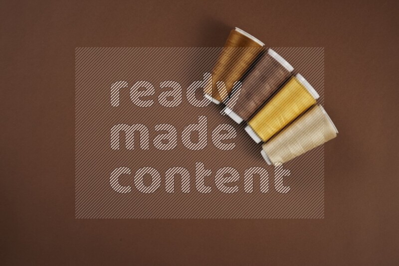 مجموعة من أدوات الخياطة والتفصيل صفراء اللون على خلفية بنية