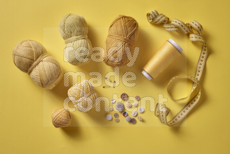 A yellow collection of sewing and tailoring tools arranged on a yellow background