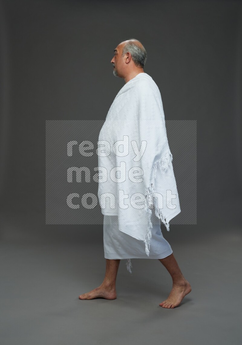 A man wearing Ehram Standing Interacting with the camera on gray background