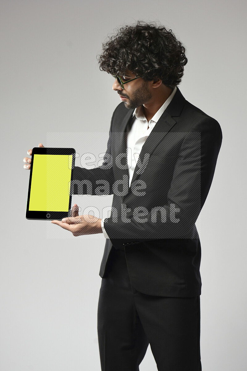 A man wearing formal standing and showing a tablet screen on white background