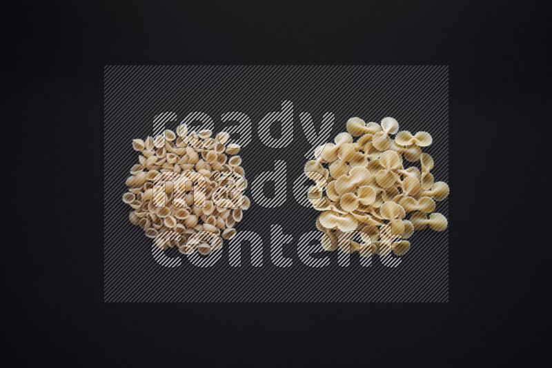 Different pasta types in bunches on black background
